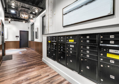 Mailroom at Capitol Hilltop Apartments with black mailboxes and tall walls.