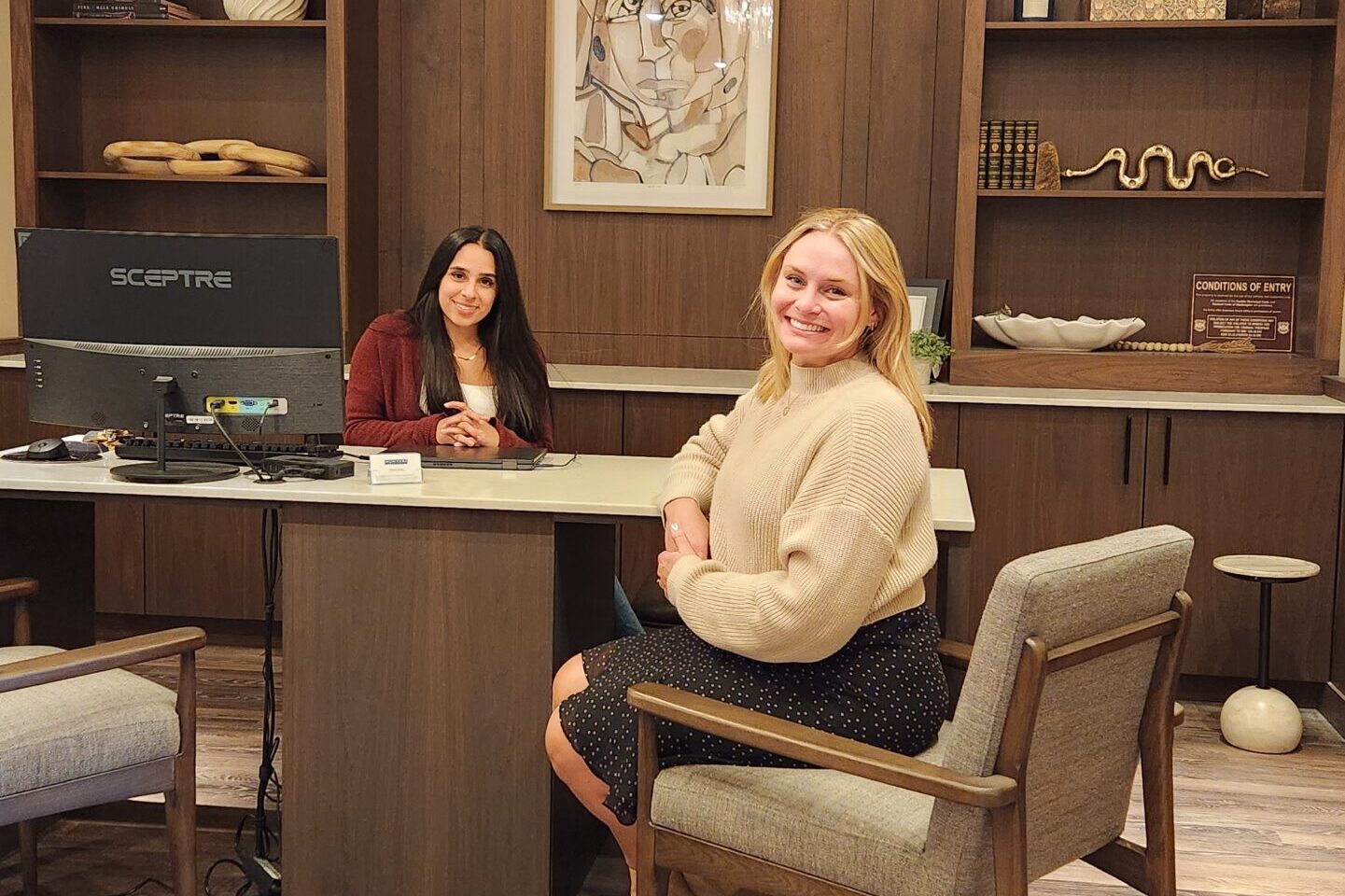 Brittany Peterson & Melissa Barajas, the community managers at Capitol Hilltop Apartments sitting at the front desk