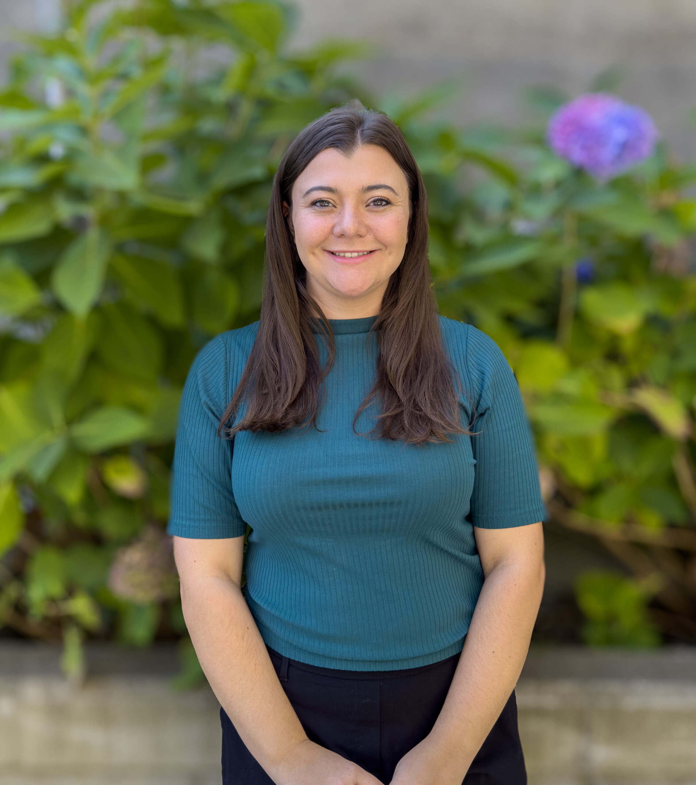 Portrait Photo of Brigitt Harmon, Assistant Community Manager of the Broadway Building. Standing in front of a blurred background.
